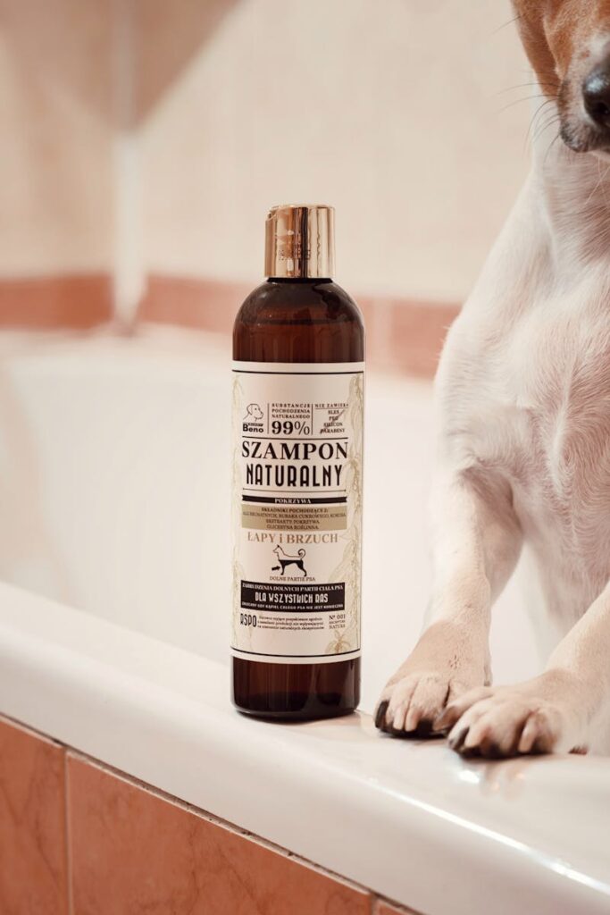 A cute dog sits beside a natural dog shampoo bottle on a bathtub, perfect for pet grooming themes.